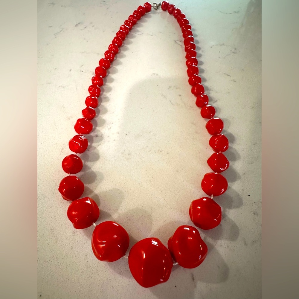Long, red necklace.